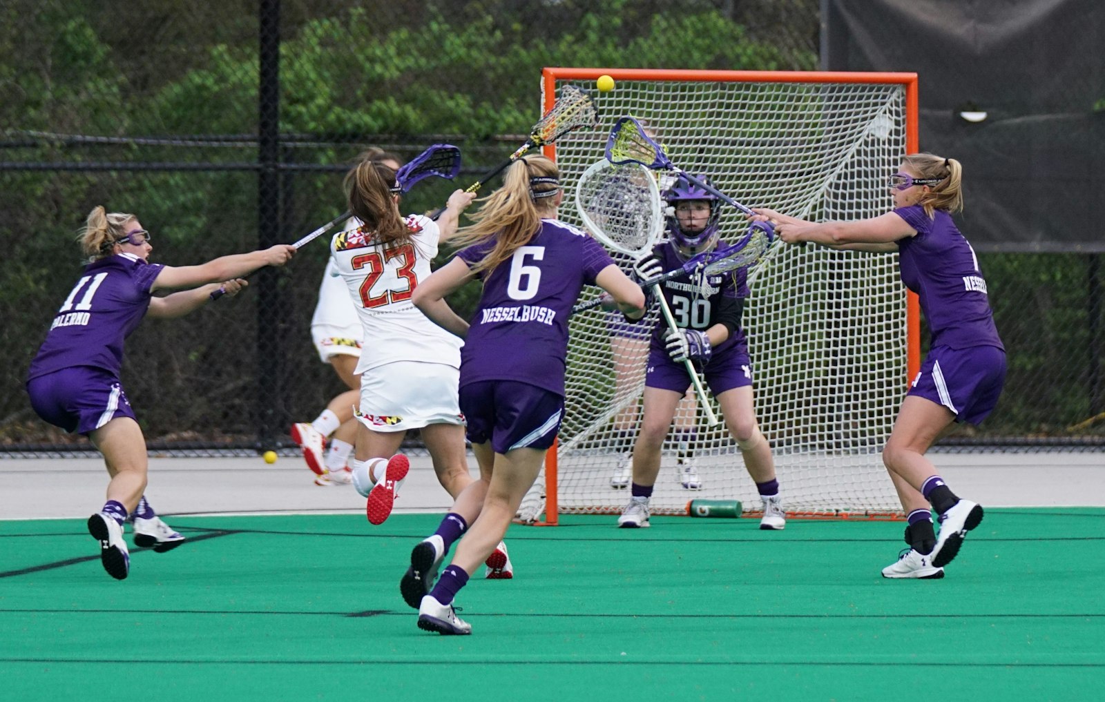 Girls lacrosse players competing in a drill
